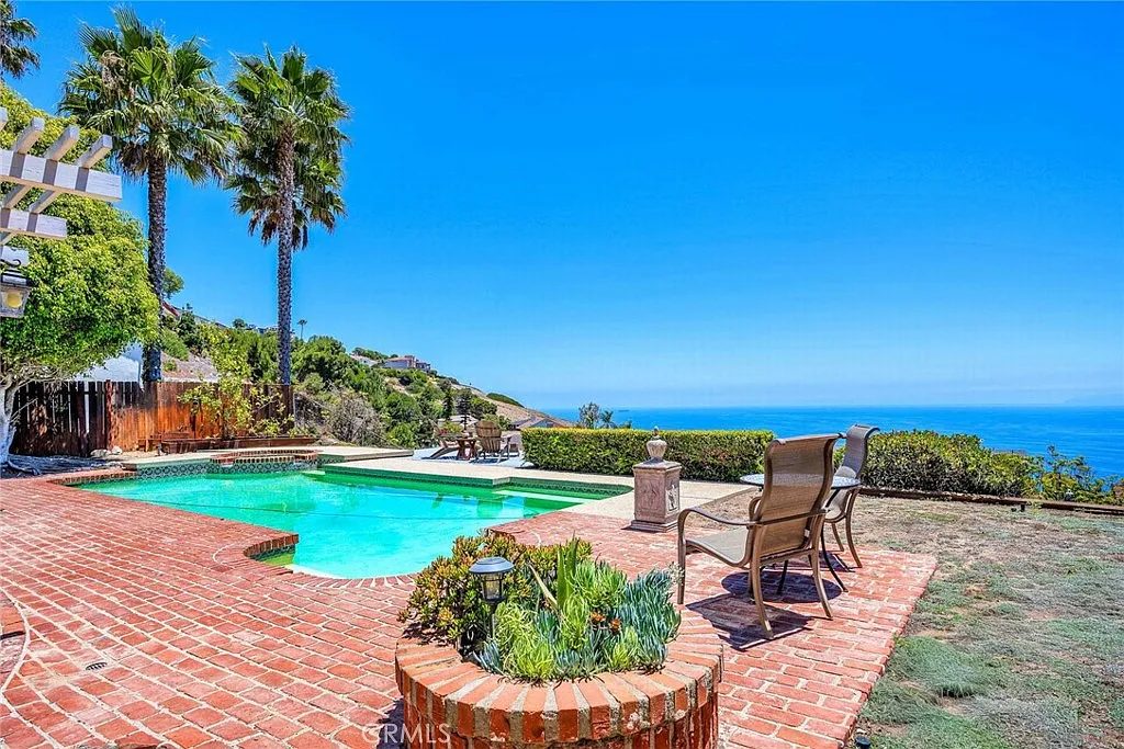Private pool with palm tree and ocean views at Eaglehaven, a furnished single-level 4-bedroom home in Rancho Palos Verdes