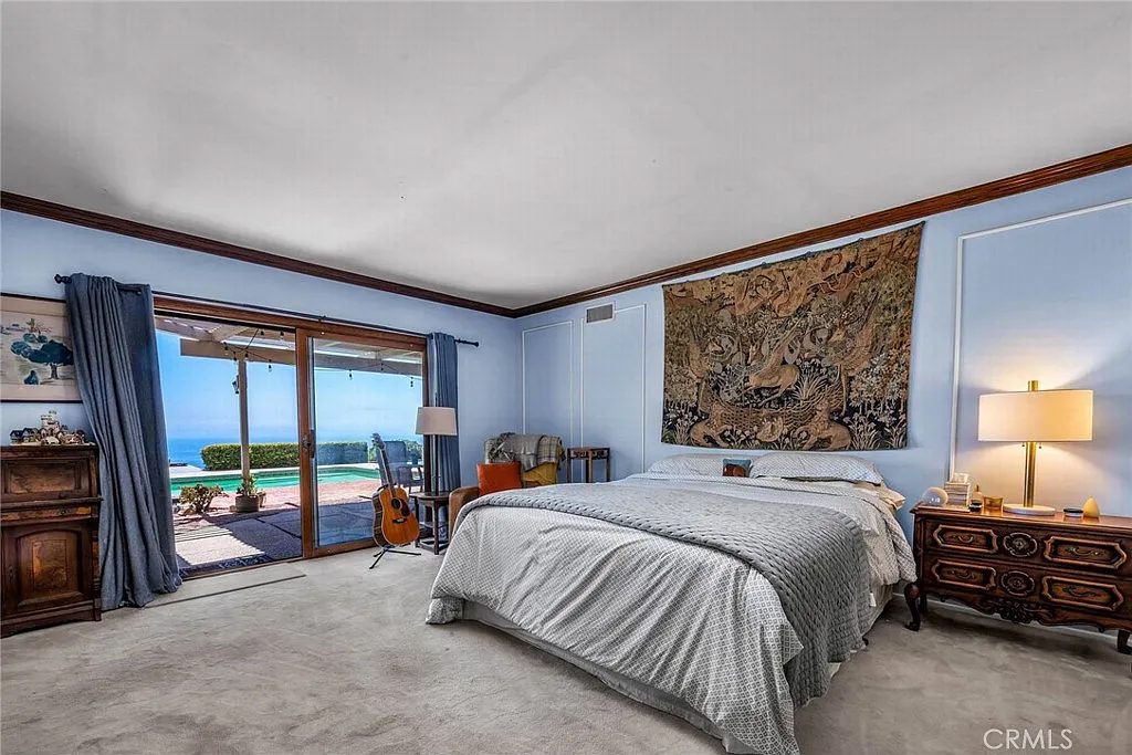 Primary bedroom with sliding doors to the pool and ocean views at Eaglehaven, Rancho Palos Verdes