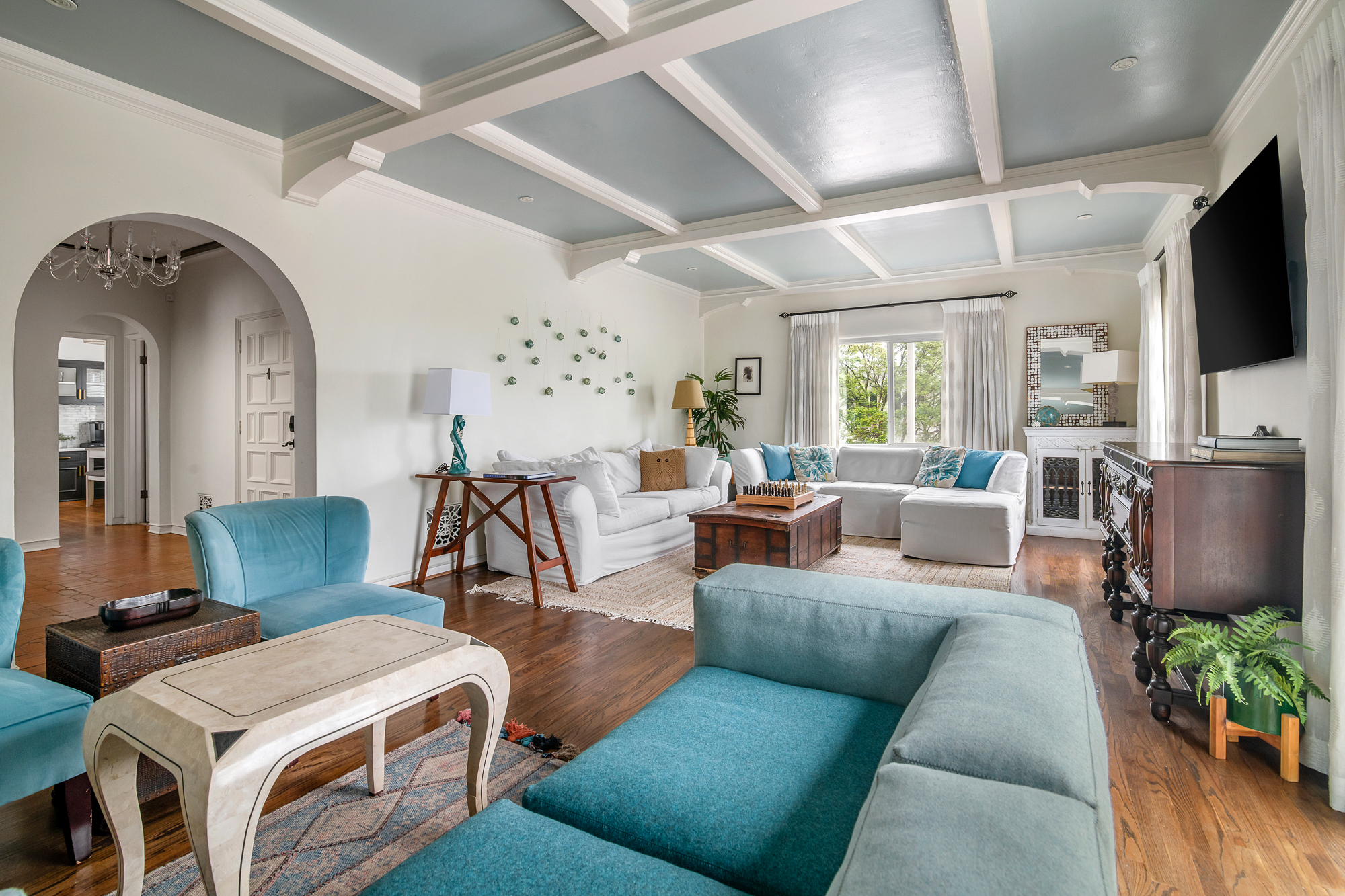 Grand living room with coffered ceiling at Casa de LA, a luxury furnished property managed by Earendel