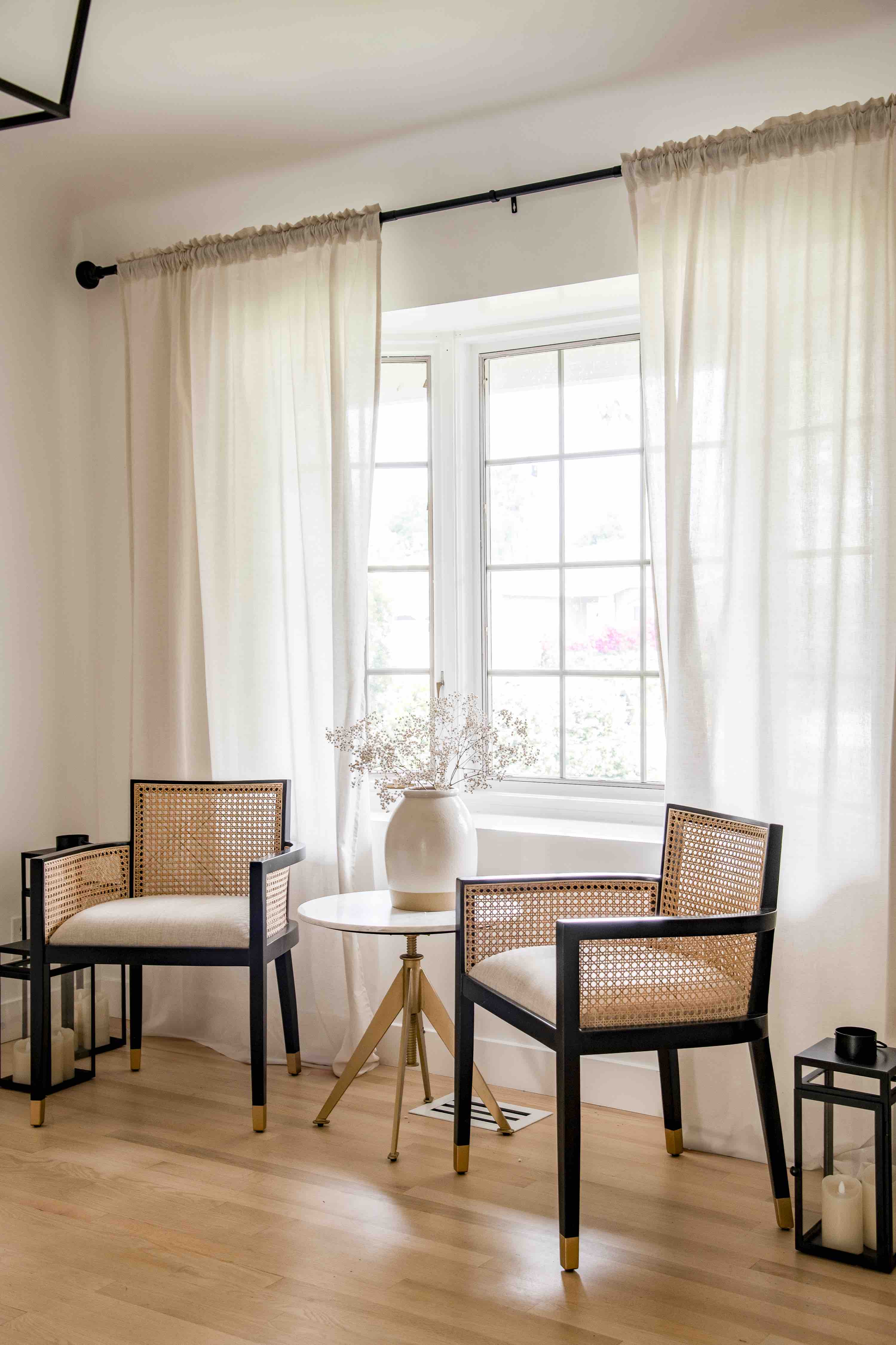 Elegant sitting area with cane chairs and linen curtains at Rose House, a furnished Earendel property