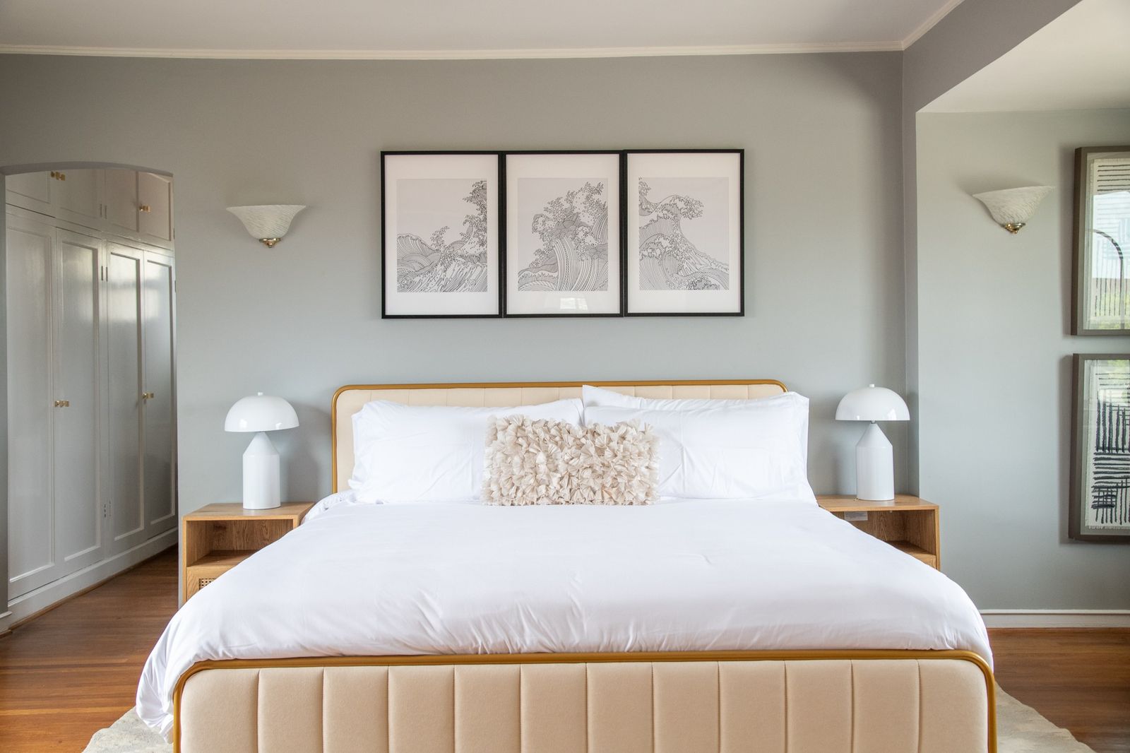 King bedroom with upholstered bed and hotel linens in a furnished mid-term rental