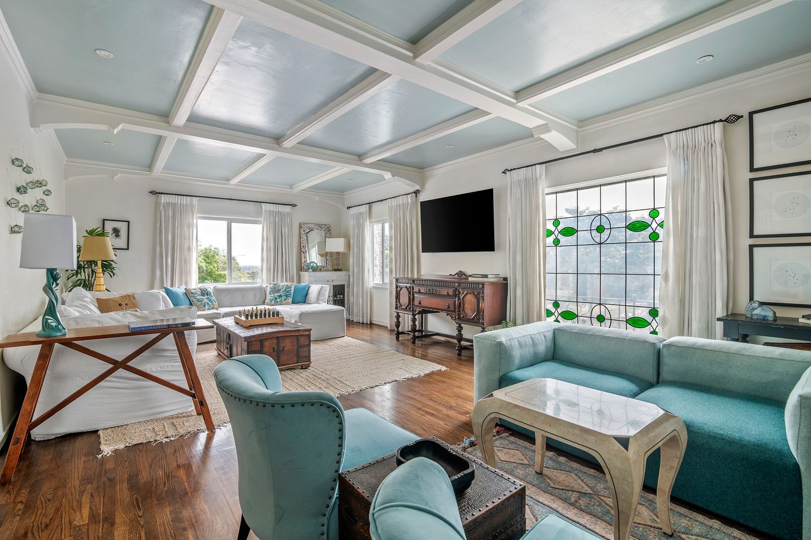 Living room with coffered ceiling and leaded stained glass window in a furnished Earendel property