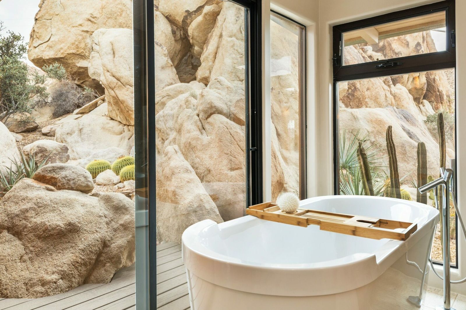 Freestanding soaking tub framed by boulders at Rockbound Oasis in Joshua Tree