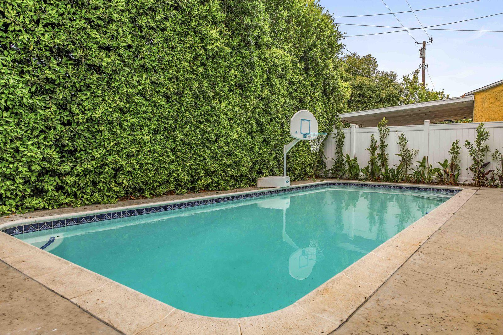 Private pool with basketball hoop and loungers at Rose House, Magnolia Park, Burbank